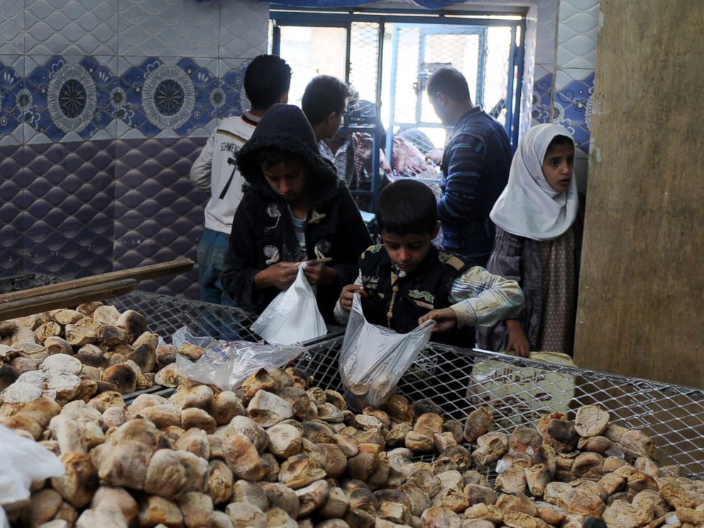 PHOTO: Children distribute free bread to people at a center financed by rich people and merchants in Sanaa, Yemen, Nov. 12, 2017.