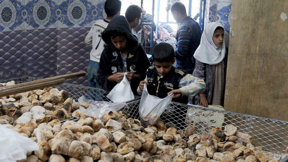 PHOTO: Children distribute free bread to people at a center financed by rich people and merchants in Sana'a, Yemen, on Nov. 12, 2017. 