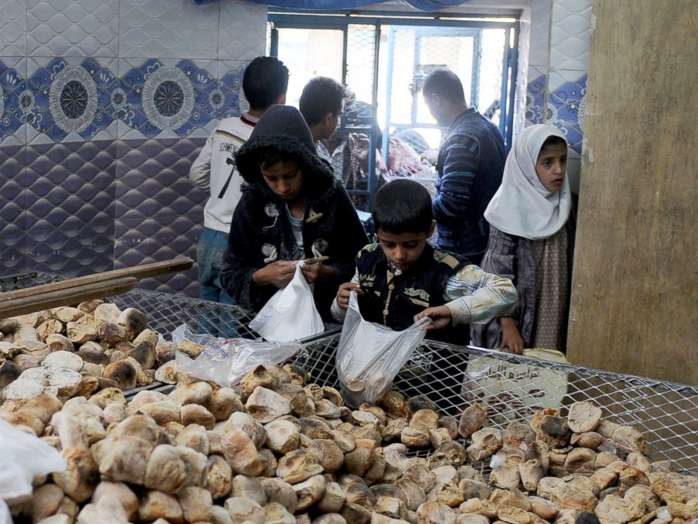 PHOTO: Children distribute free bread to people at a center financed by rich people and merchants in Sanaa, Yemen, on Nov. 12, 2017.
