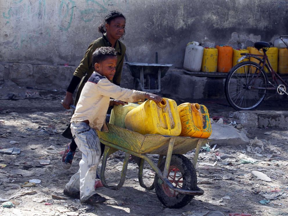 PHOTO: Yemeni children push a wheelbarrow with jerrycans filled with drinking water from a donated water pipe in Sanaa, Yemen, Nov. 18, 2017.