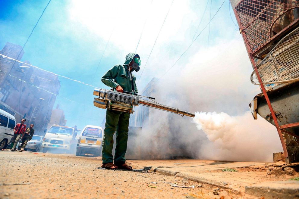 PHOTO: A government worker that is part of a combined task force tackling COVID-19 coronavirus fumigates a neighborhood as part of safety precautions, in Sanaa, Yemen, March 23, 2020.