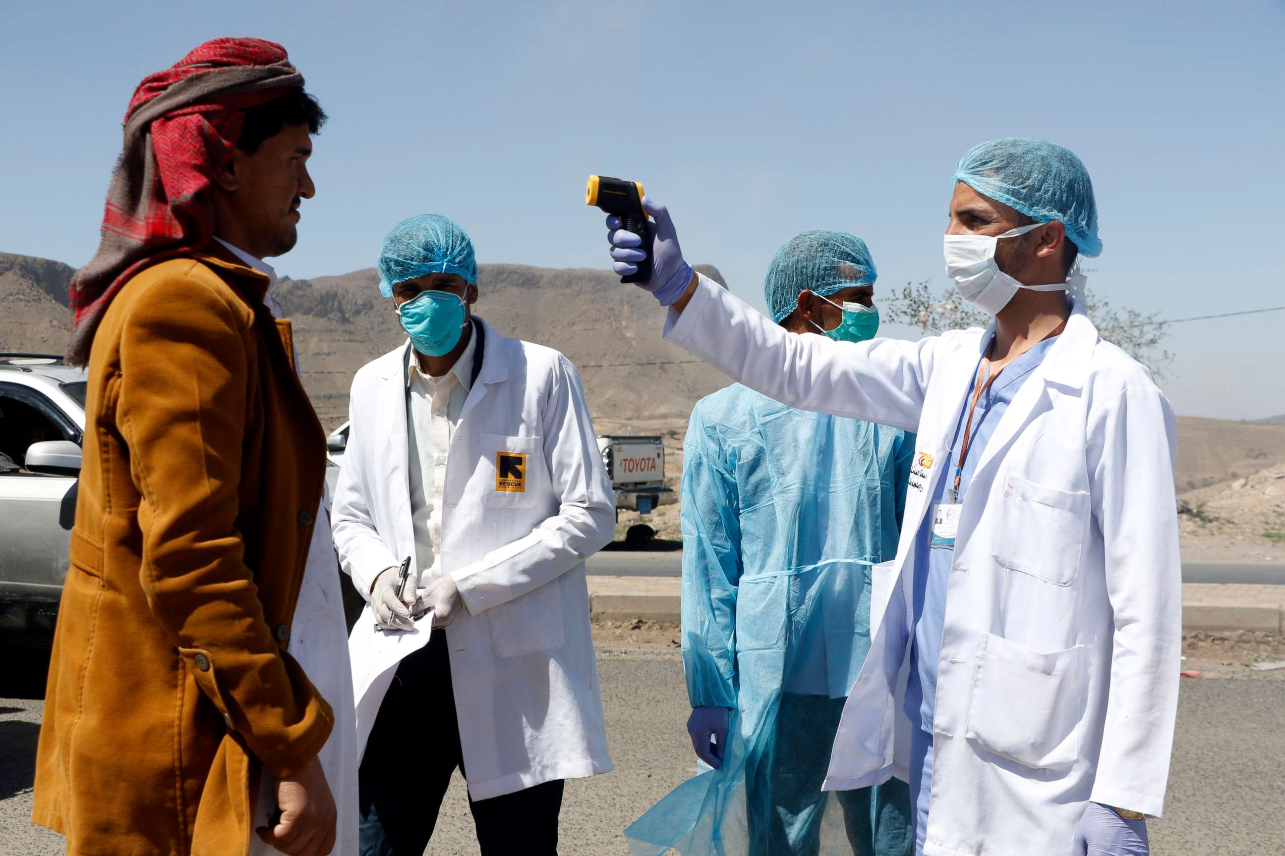 PHOTO: Medical personnel check people's temperature on the street as a precautionary measure against the spread of coronavirus COVID-19, April 5, 2020 on the outskirts of Sana'a, Yemen. 