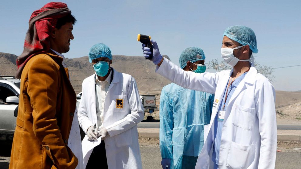 PHOTO: Medical personnel check people's temperature on the street as a precautionary measure against the spread of coronavirus COVID-19, April 5, 2020 on the outskirts of Sana'a, Yemen. 