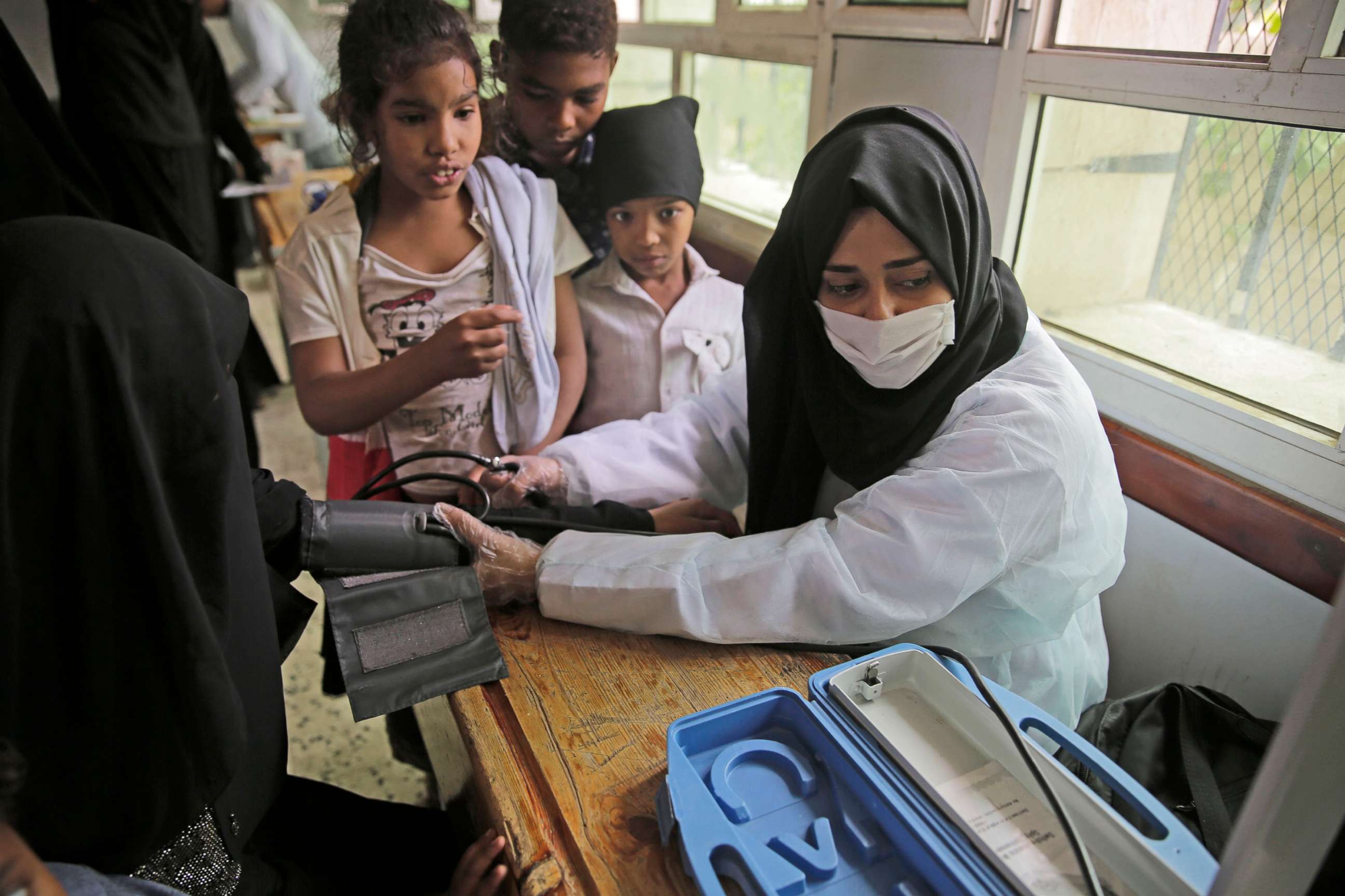 PHOTO: A volunteer doctor measures the blood pressure of a woman during a health check-up for the poor families amid the spread of coronavirus, July 8, 20202, at a school in Sanaa, Yemen.