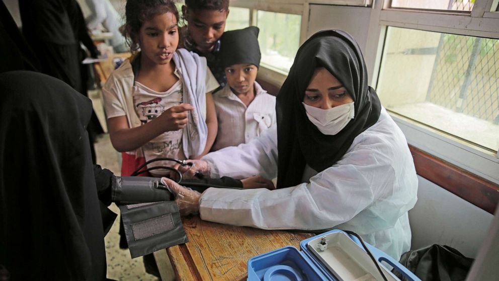 PHOTO: A volunteer doctor measures the blood pressure of a woman during a health check-up for the poor families amid the spread of coronavirus, July 8, 20202, at a school in Sanaa, Yemen.