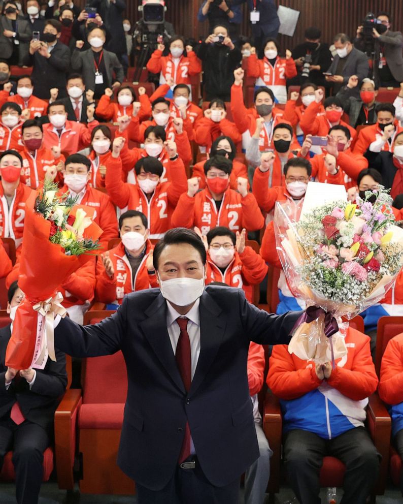 PHOTO: Yoon Suk-yeol of the main opposition People Power Party poses with bouquets after he was elected President, at the National Assembly in Seoul, March 10, 2022.