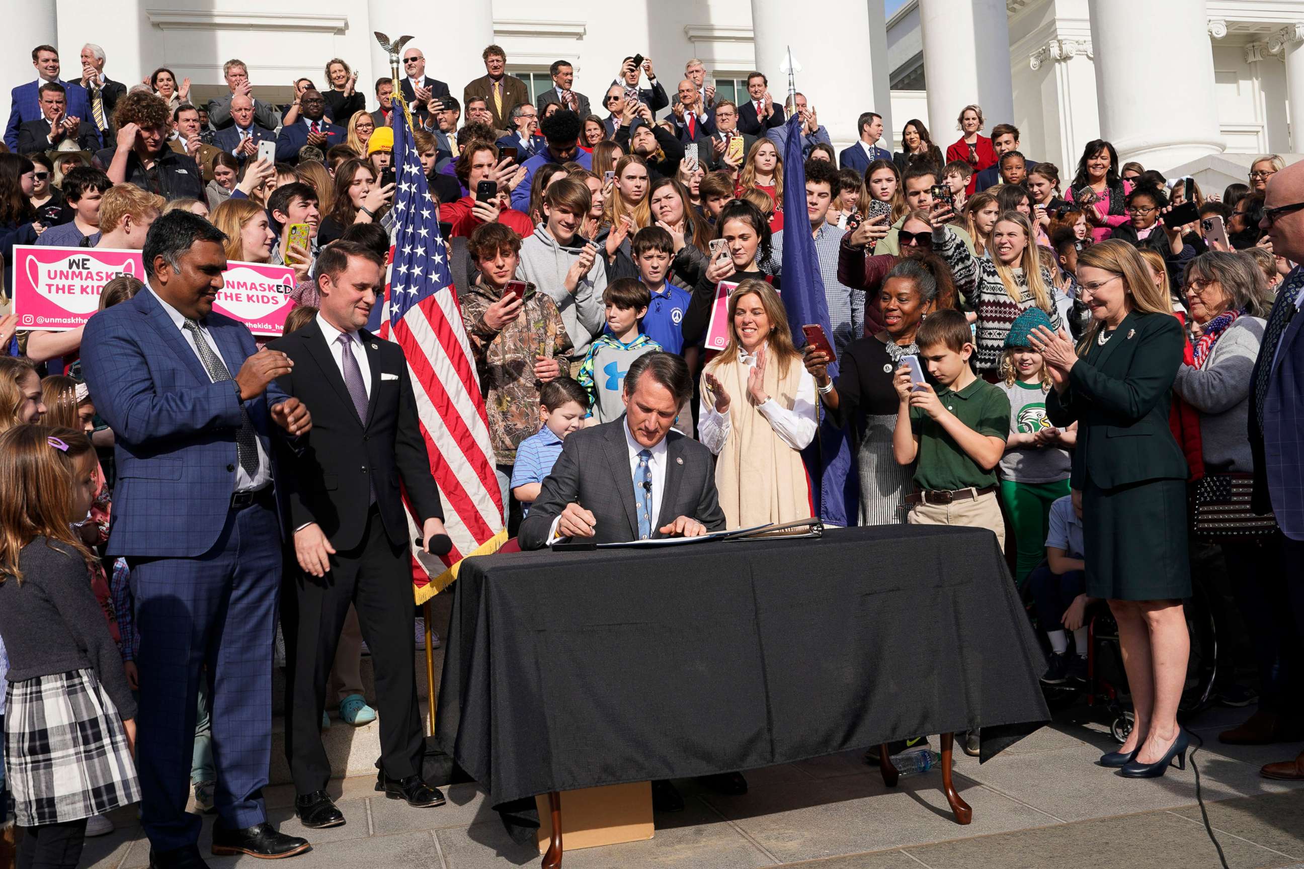 PHOTO: Virginia Gov. Glenn Youngkin, seated center, signs a bill that bans mask mandates in public schools in Virginia on the steps of the Capitol in Richmond- Va., Feb. 16, 2022.