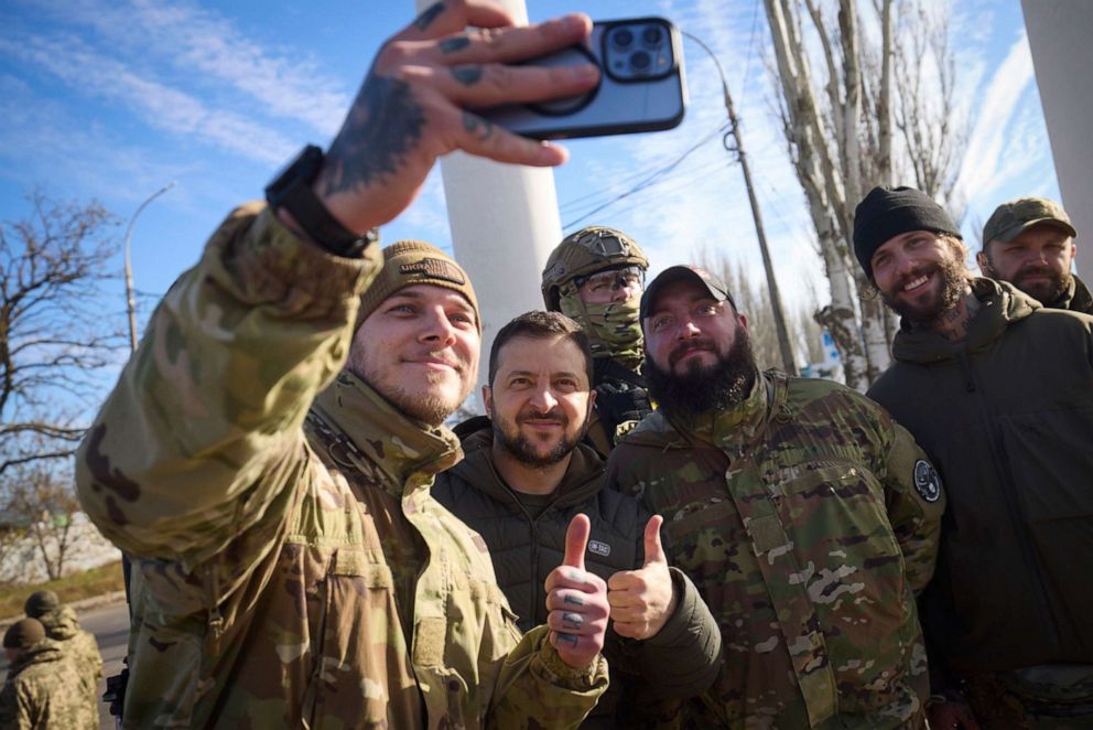 PHOTO: In this photo provided by the Ukrainian Presidential Press Office and posted on Facebook, Ukrainian soldiers take a selfie with President Volodymyr Zelenskyy, center, during his visit to Kherson, Ukraine, on Nov. 14, 2022. 