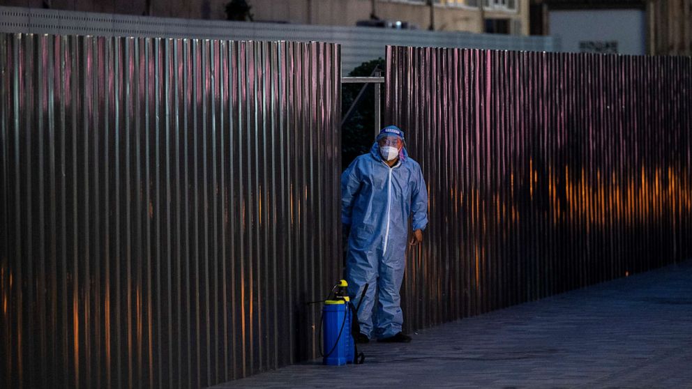 PHOTO: A guard wears protective clothing as he stands next to a barrier fence outside an apartment under lockdown, during a recent COVID-19 outbreak in Beijing, China, on June 13, 2022.