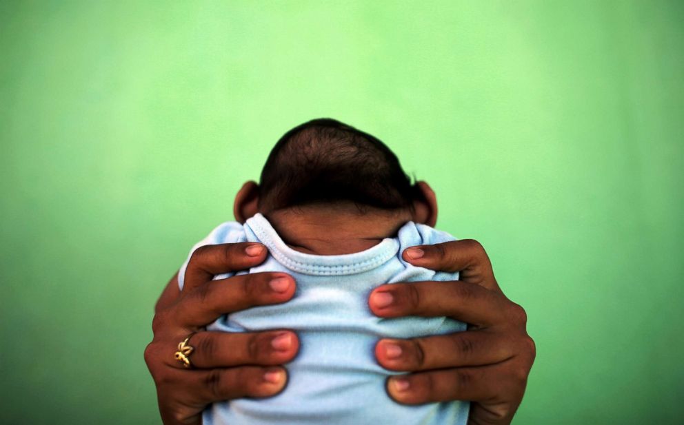 PHOTO: Jackeline Vieira de Souza, 26, holds her four-month-old son Daniel who was born with microcephaly in front of their house in Olinda, near Recife, Brazil, Feb. 11, 2016.