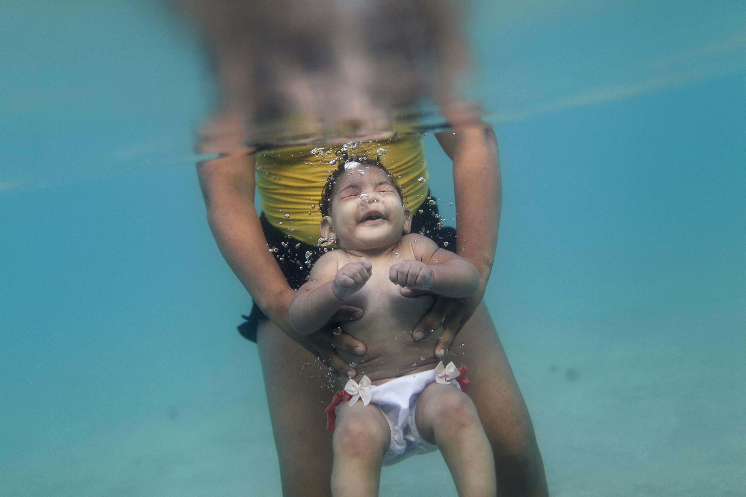 PHOTO: Rosana Vieira Alves and her five-month-old daughter Luana Vieira, who was born with microcephaly, pose for a picture in the sea of Porto de Galinhas, a beach located in Ipojuca, in the state of Pernambuco, Brazil, March 2, 2016.