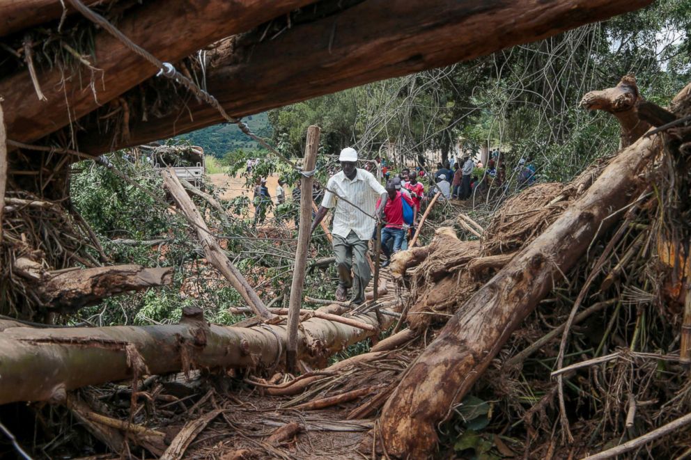 PHOTO:  People cross a makeshift bridge over a river that surged days earlier during Cyclone Idai, March 20, 2019, in Chipinge, Zimbabwe. 