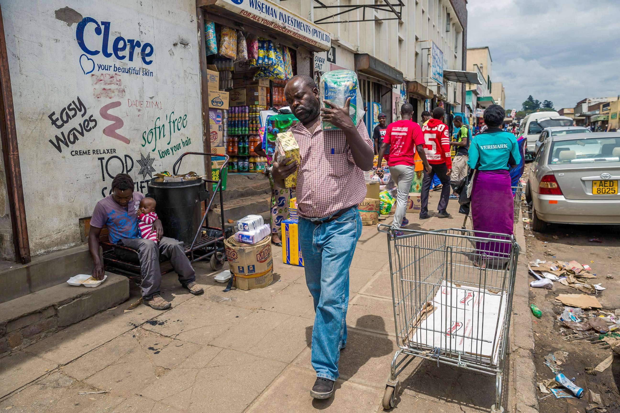 PHOTO: A man carries his wares through a market as business continues in the Zimbabwean capital Harare on Nov. 16, 2017, a day after the military announced plans to arrest "criminals" close to the president. 