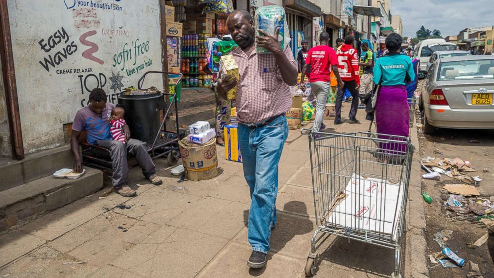PHOTO: A man carries his wares through a market as business continues in the Zimbabwean capital Harare on Nov. 16, 2017, a day after the military announced plans to arrest "criminals" close to the president. 