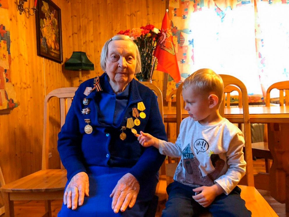 PHOTO: In this handout family photo taken by Dmitry Panov, Zinaida Korneva, World War II veteran sits during her interview with the Associated Press as her great-great grandchild Richard Panov looks at a medal in St. Petersburg, Russia, May 5, 2020.