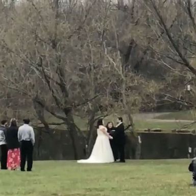 VIDEO: Couple weds with guests watching from safe distance