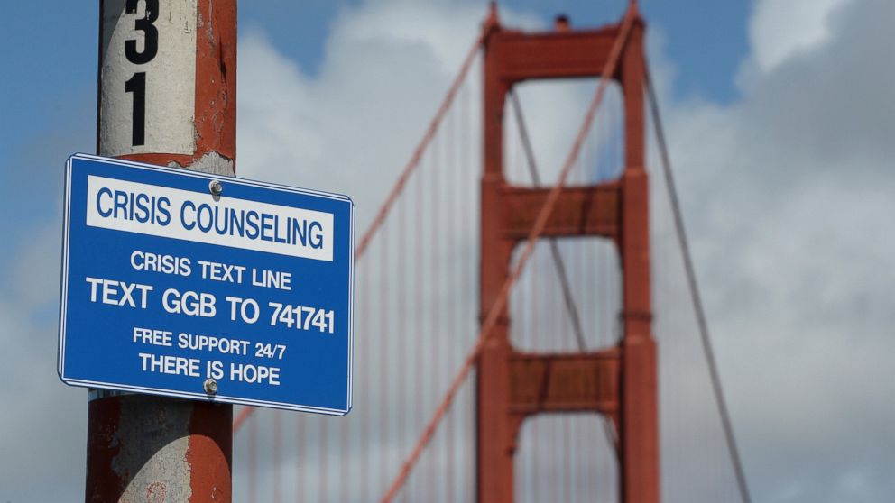 A suicide prevention sign is posted at the Golden Gate Bridge, on April 13, 2017, in San Francisco. Local officials gathered Thursday at the orange-red span to mark the beginning of work to line both sides of the bridge with steel netting.