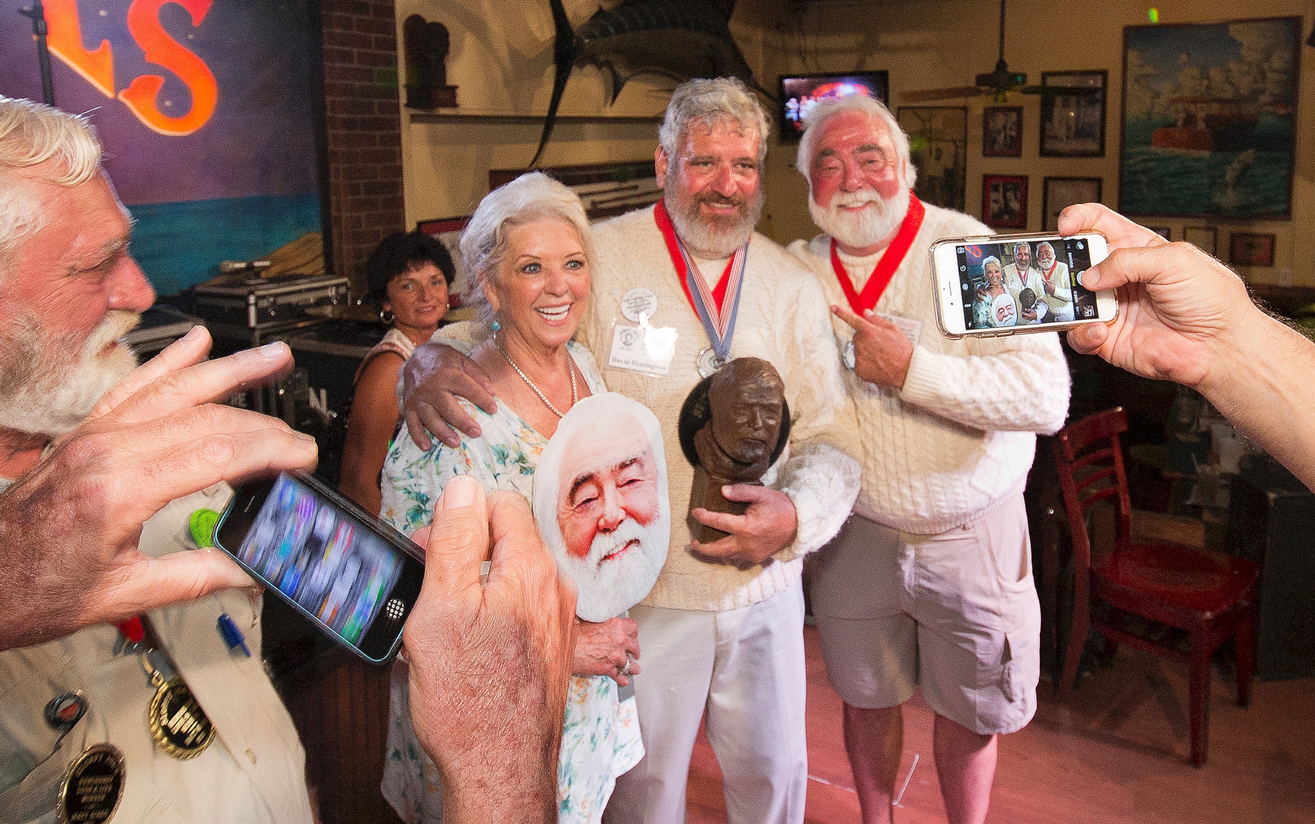 PHOTO: Dave Hemingway, poses for smartphone photos with celebrity chef Paula Deen and her husband Michael Groover, after Dave Hemingway won the 2016 Ernest "Papa"  Hemingway Look-Alike Contest at Sloppy Joe's Bar in Key West, Florida, July 23, 2016. 
