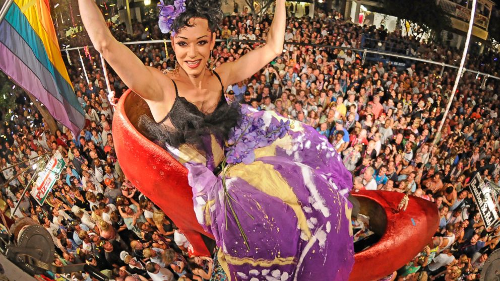 In a photo released by the Florida Keys News Bureau, female impersonator Gary Marion, transformed into "Sushi," hangs above Duval Street and thousands of New Year's Eve revelers at the Bourbon Street Pub Complex in Key West, Fla.