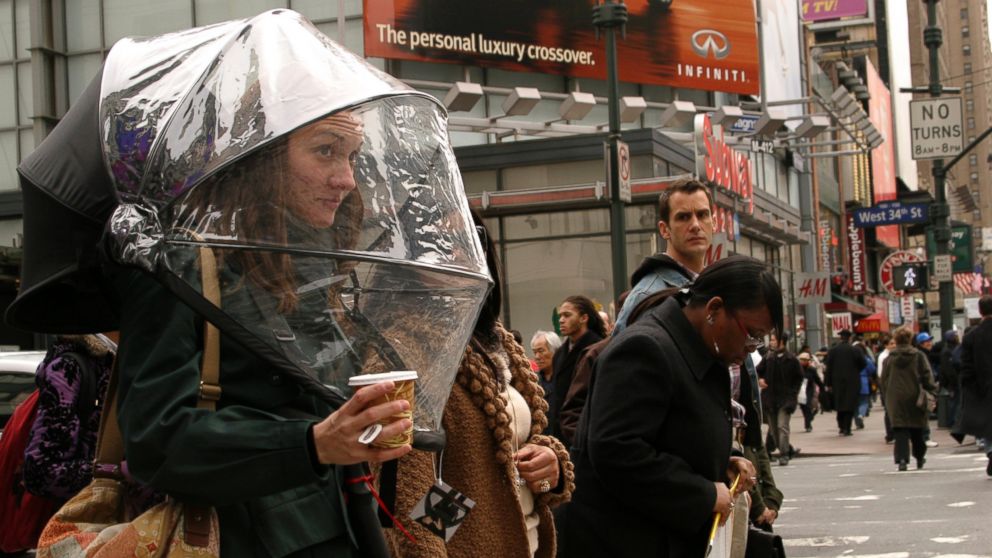 A woman waits to cross the street wearing the Nubrella, a hands-fee umbrella, April 3, 2008, in New York.
