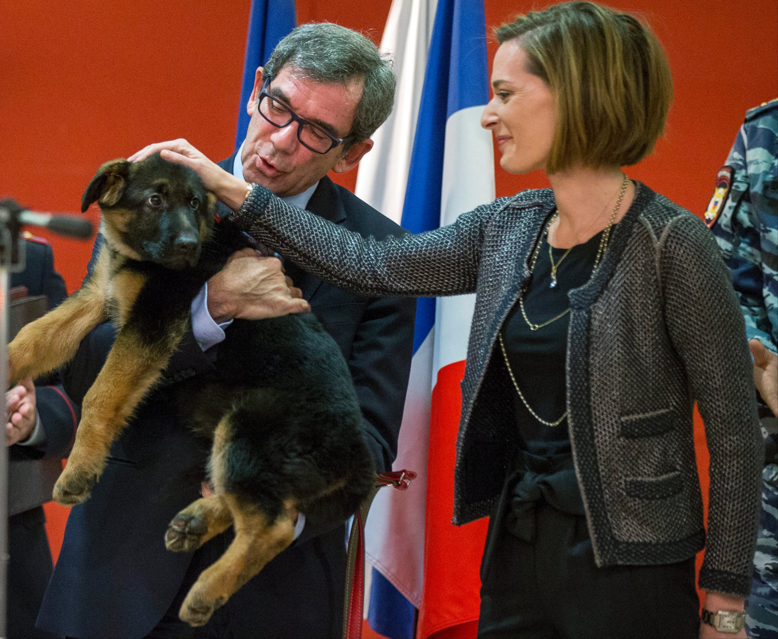 PHOTO: French Ambassador to Russia, Jean Maurice Ripert, holds a puppy, named Dobrynya, as his wife Yael pets the puppy during a ceremony presenting the puppy to French police in the French Embassy in Moscow, Russia, Dec. 7, 2015. 