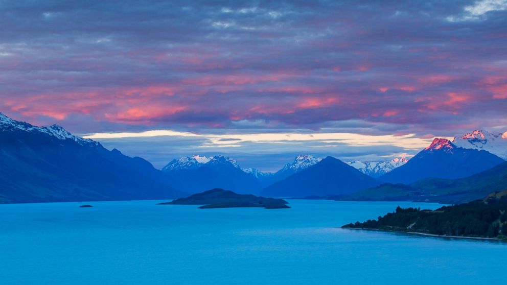 Mount Earnslaw and neighboring mountain peaks in the Southern Alps are lit with the last rays of the sun beyond Lake Wakatipu, Otago in South Island, New Zealand in this undated stock photo. 