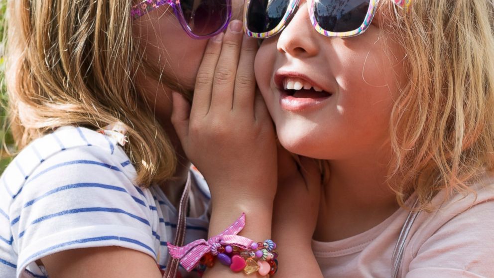 Young girls are seen whispering in this undated file photo.