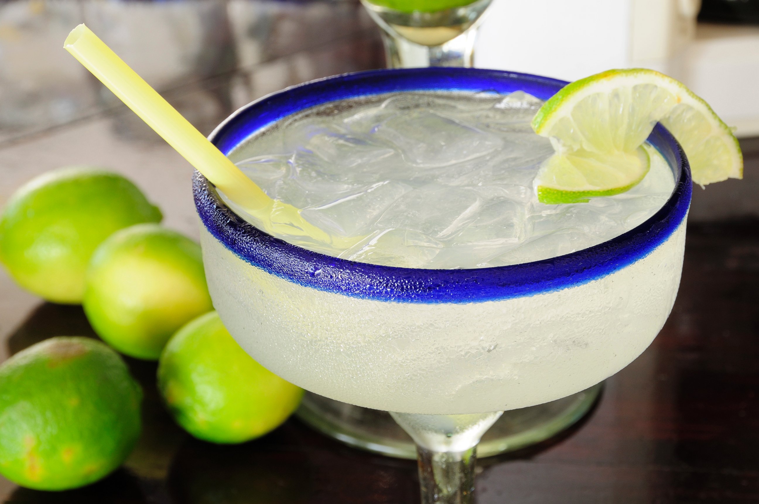 PHOTO: A frosted glass of a margarita cocktail served with ice and slice of lime with whole limes at side is pictured in this undated photo.