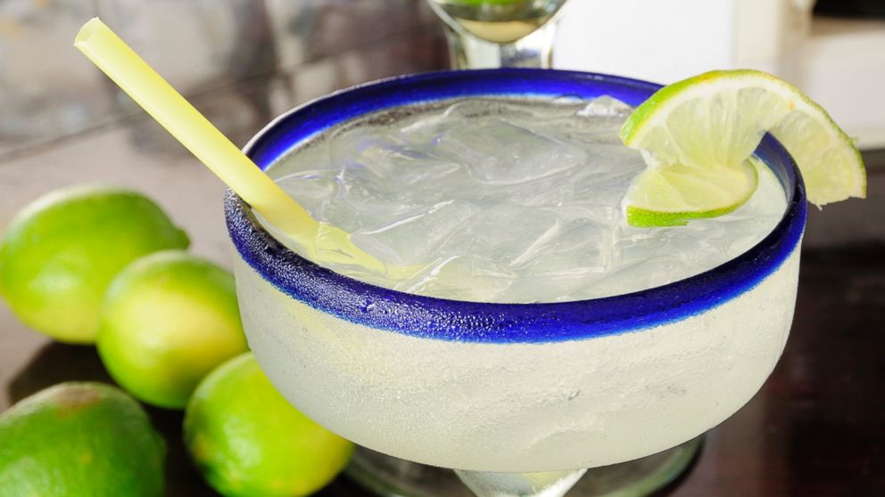 PHOTO: A frosted glass of a margarita cocktail served with ice and slice of lime with whole limes at side is pictured in this undated photo.