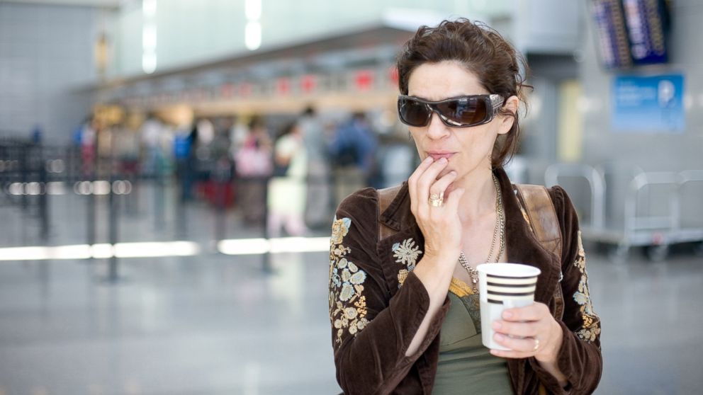 A woman waits for her flight at the airport in this undated stock photo.