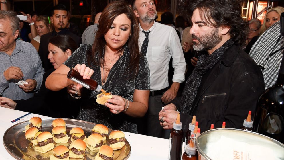 TV Personality Rachael Ray and John Cusimano sample food at Brindle Room station at the Blue Moon Burger Bash presented by Pat LaFrieda Meats hosted by Rachael Ray during the New York City Wine & Food Festival on Oct. 17, 2014 in New York City. 