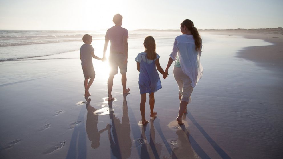 A family enjoys time together on the beach at sunset in this undated stock photo.