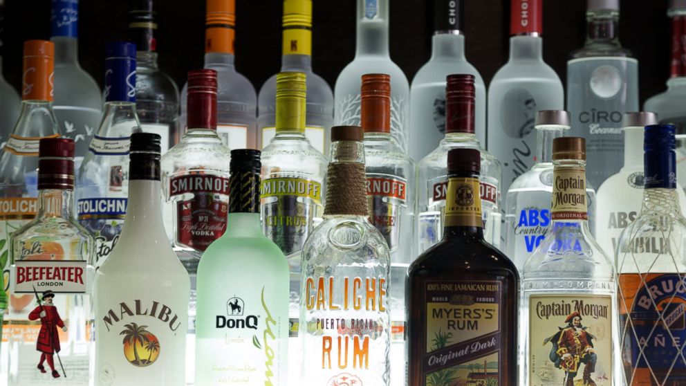 Various bottles of alcohol are displayed on a bar.