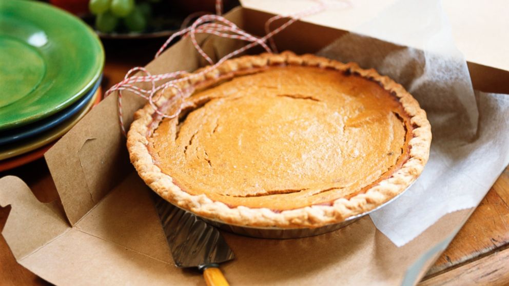 A pumpkin pie inside in a cardboard box.