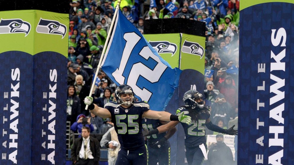 Linebacker Heath Farwell #55 of the Seattle Seahawks runs out of the tunnel with the 12th Man flag before taking on the New Orleans Saints during the NFC Divisional Playoff Game at CenturyLink Field on Jan. 11, 2014 in Seattle.