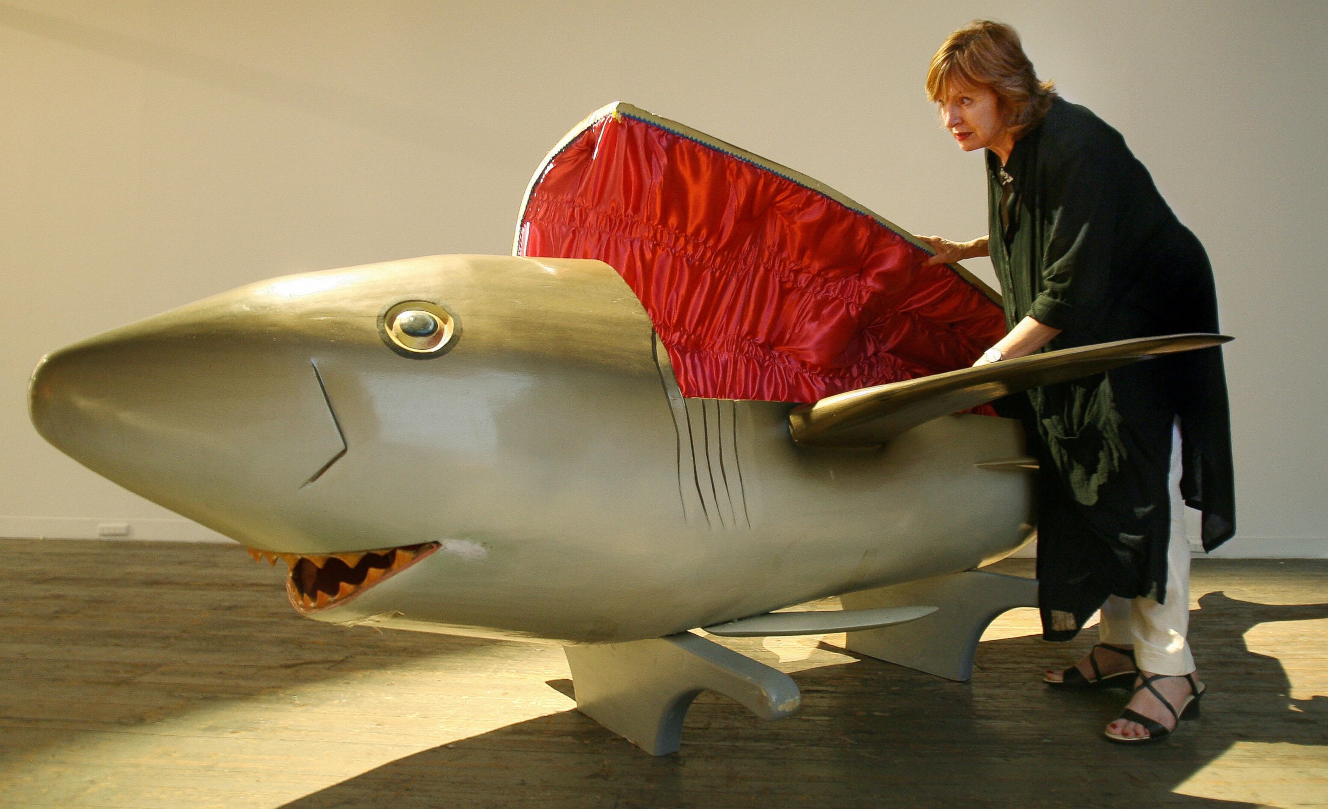 PHOTO: In this file photo, a gallery worker inspects a coffin carved in the shape of a shark by the Paa Joe Carpentry workshop in Ghana and commissioned for Festival Melbourne2006, in Melbourne, Australia on Mar. 9, 2006.  