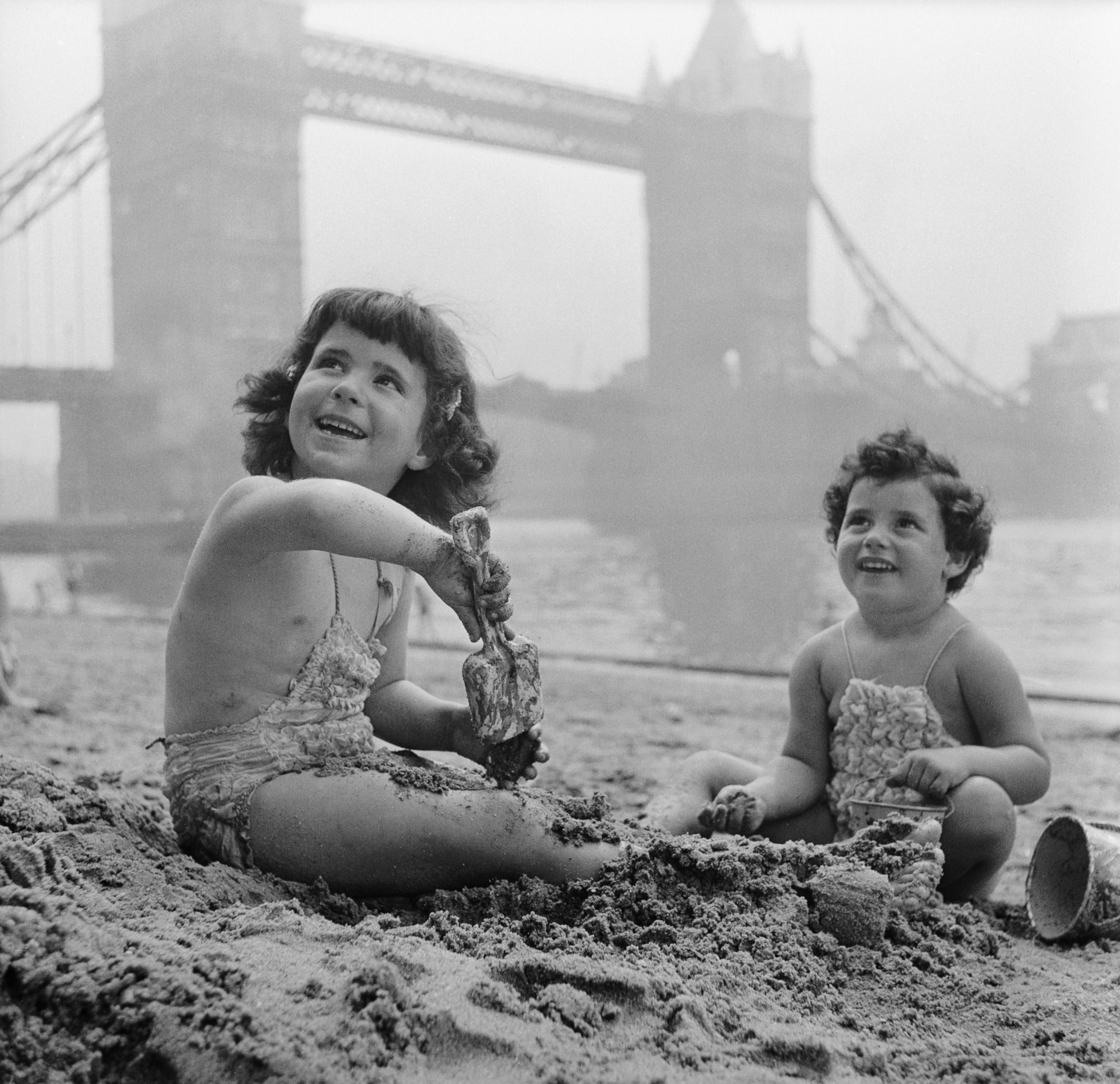 PHOTO: Two little girls playing in the sand on Tower Beach, near Tower Bridge on the River Thames