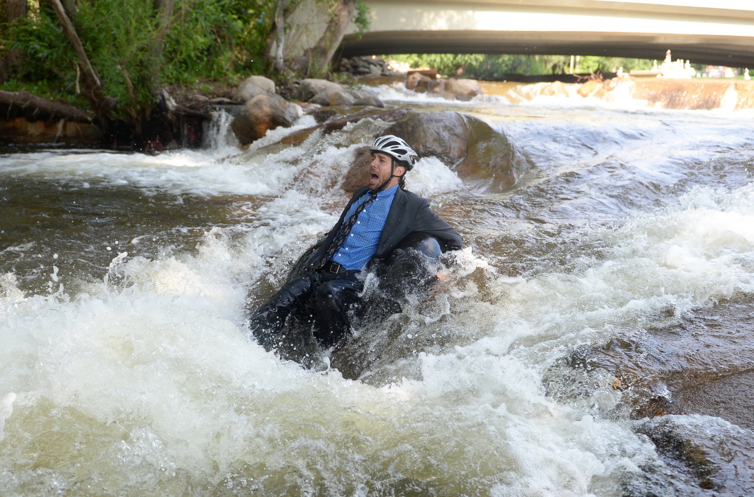 PHOTO: Quayle Hodek, dressed in a suit and tie, floats down Boulder Creek during Boulder's Tube to Work Day, July 15, 2014. 