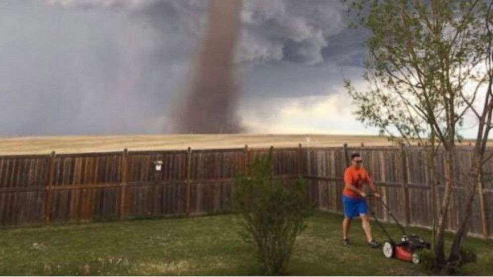 PHOTO: Cecilia Wessels of Alberta, Canada, captured her husband pushing a lawn mower near a moving tornado on June 2, 2017.