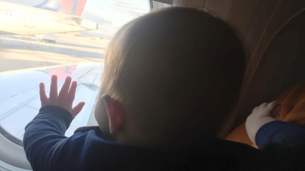 PHOTO: Evan Hughes of Fort Worth, Texas, shared a photo of his 8-month-old son, Ki, being held on a Dallas-bound plane flight by India Massinburg, a stranger who offered to help. 