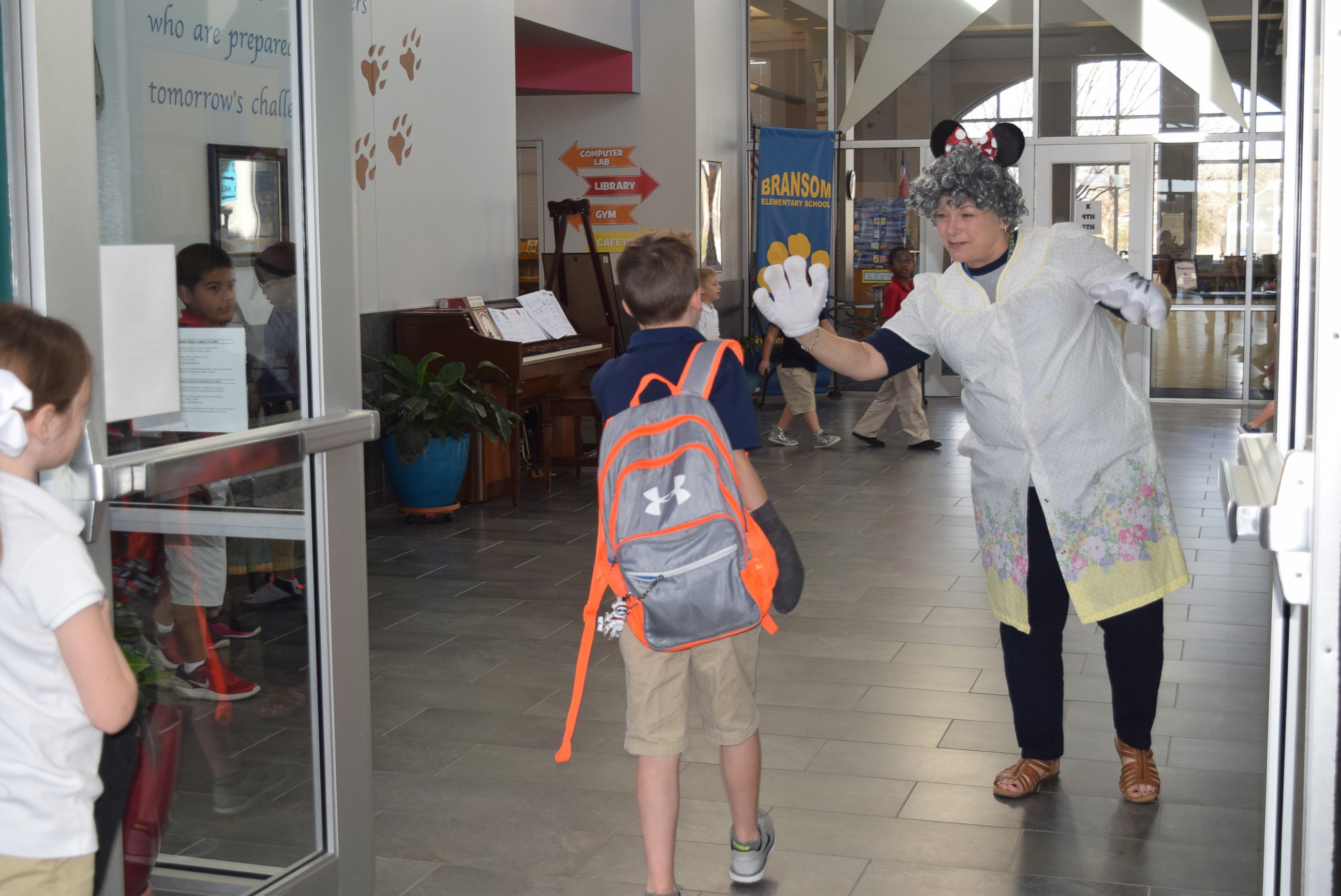 PHOTO: Cindy Matthews, a teacher's assistant at the Academy of the Arts at Bransom Elementary in Burleson, Texas, greets students in silly costumes every morning. Here she is shown greeting students as a granny.