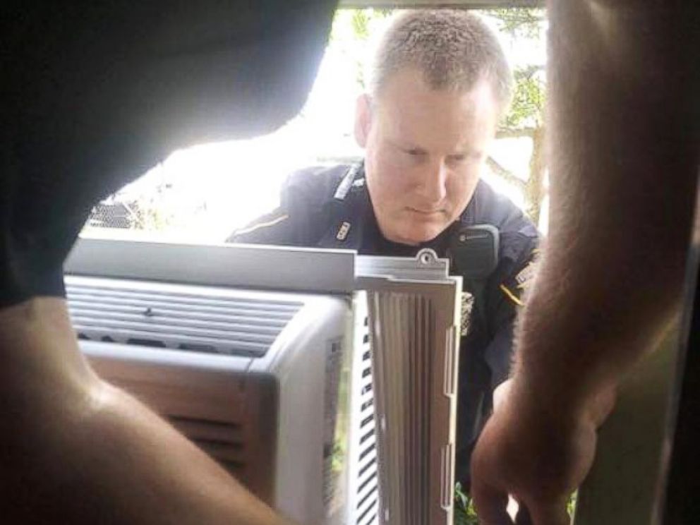 PHOTO: Officer Christopher Weir (facing camera) and Officer William Margolis pitched in to help Julius Hatley, 95, who was left without air conditioning on a 90-degree day in Texas.