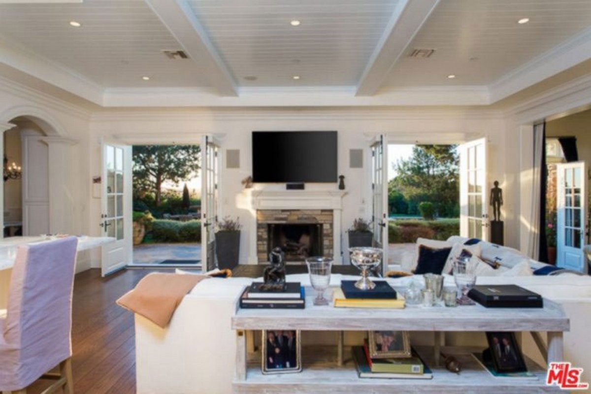 PHOTO: Two sets of French doors in the living room open to the back patio and pool.