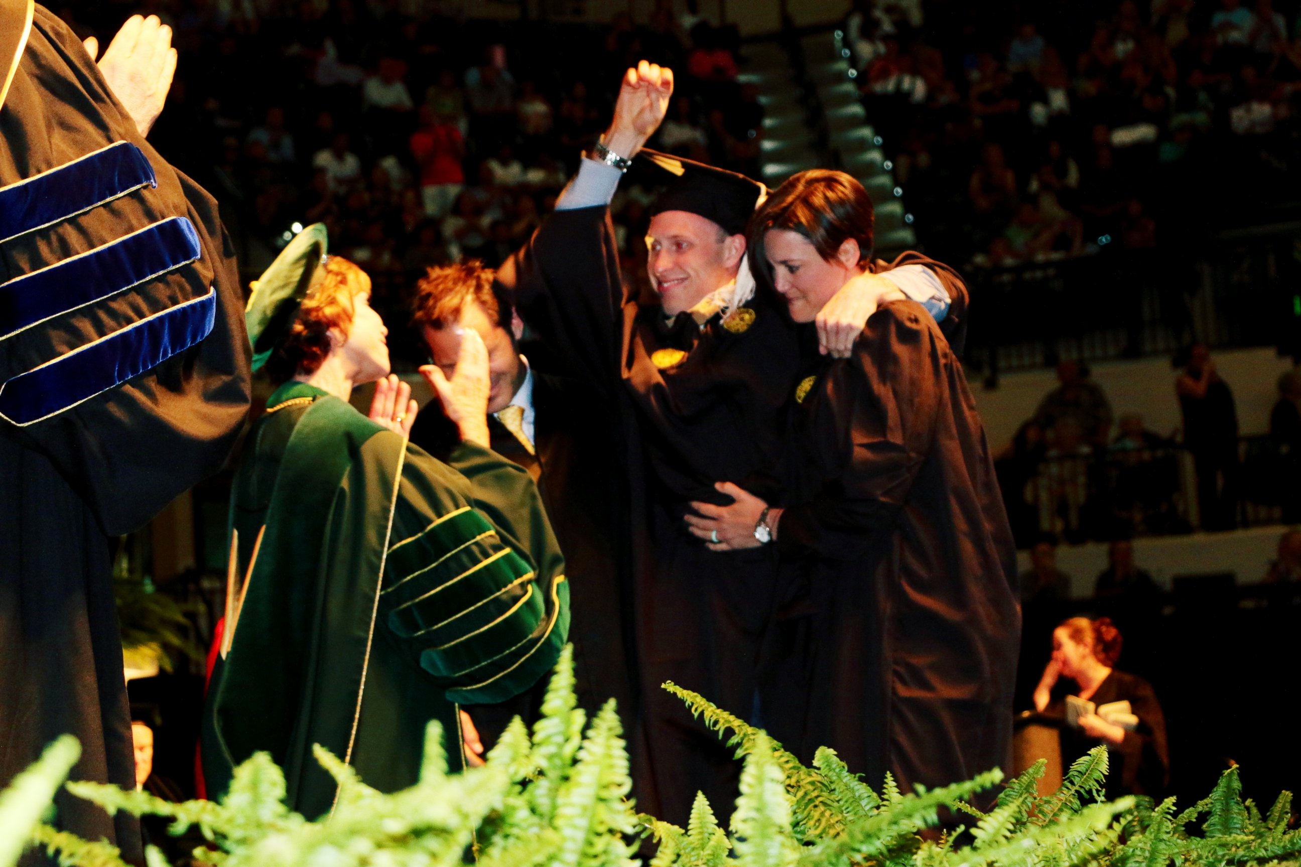PHOTO: Sam Bridgman stood up with the help of two friends and physical trainers to walk across the graduation stage at USF, May 7, 2017.