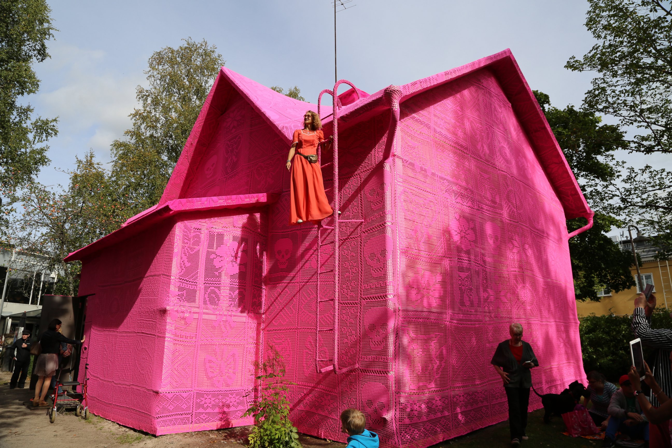 PHOTO: Olek on top of her pink crocheted house in Kerava, Finland.