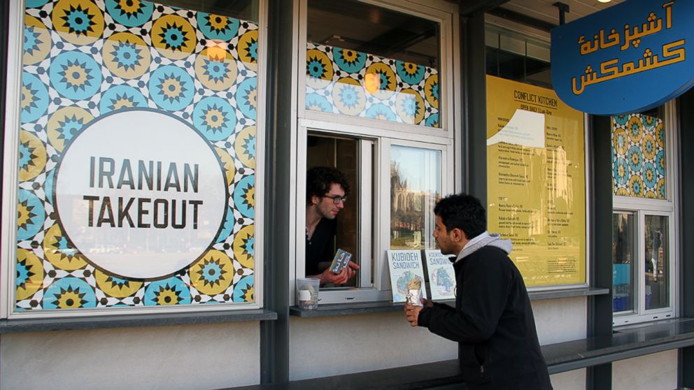 A customer at the takeout window of Conflict Kitchen.