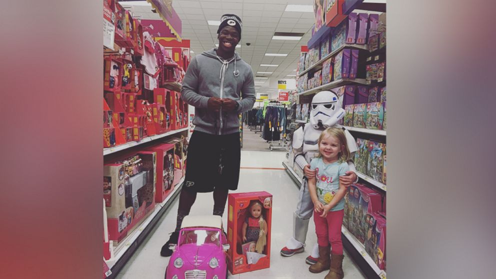 Tario Fuller II pictured with Kinley, 2, after surprising her with a doll for her upcoming birthday. 