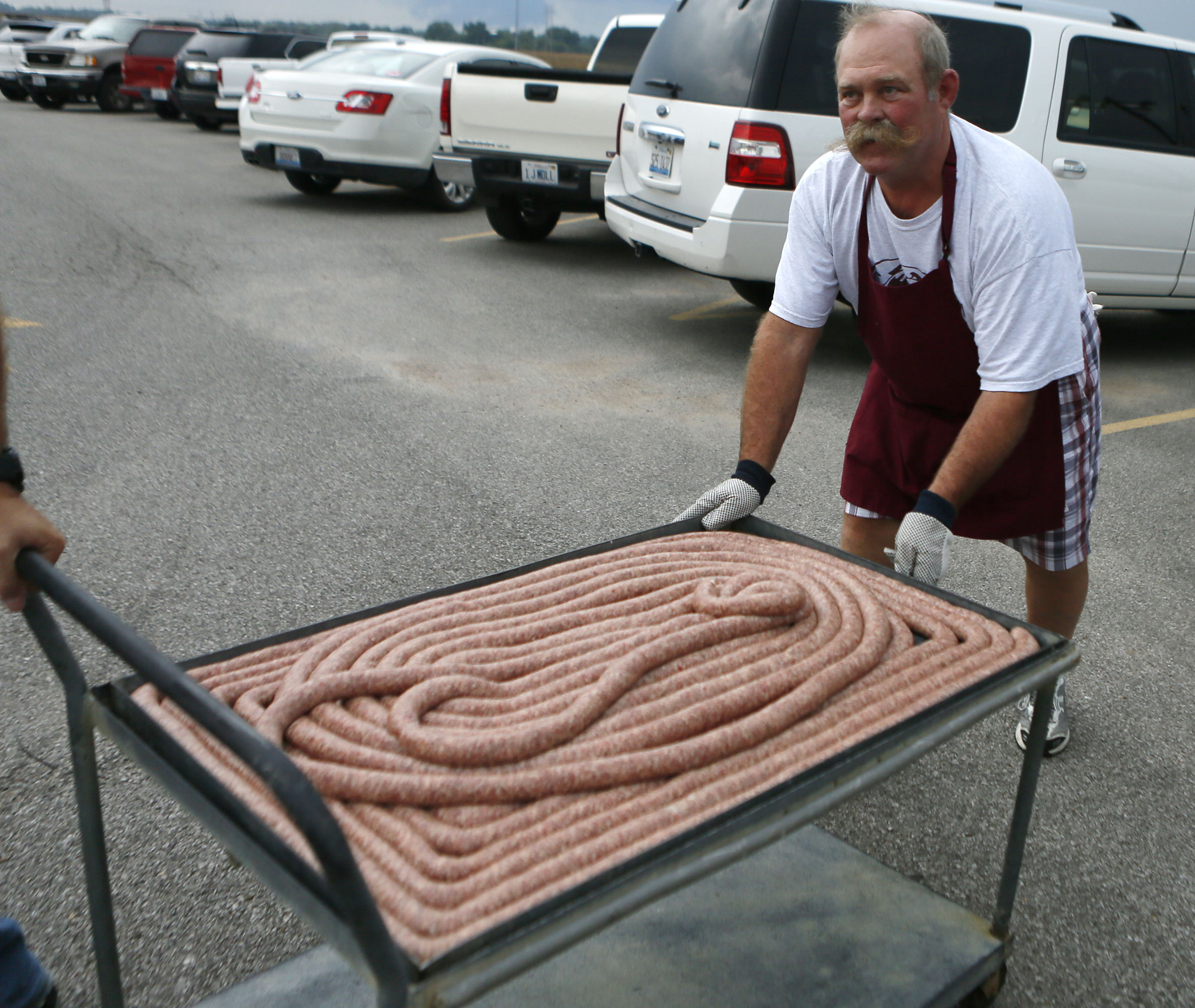 PHOTO: Larry Schubert rolls out the 100 foot-long bratwurst. 