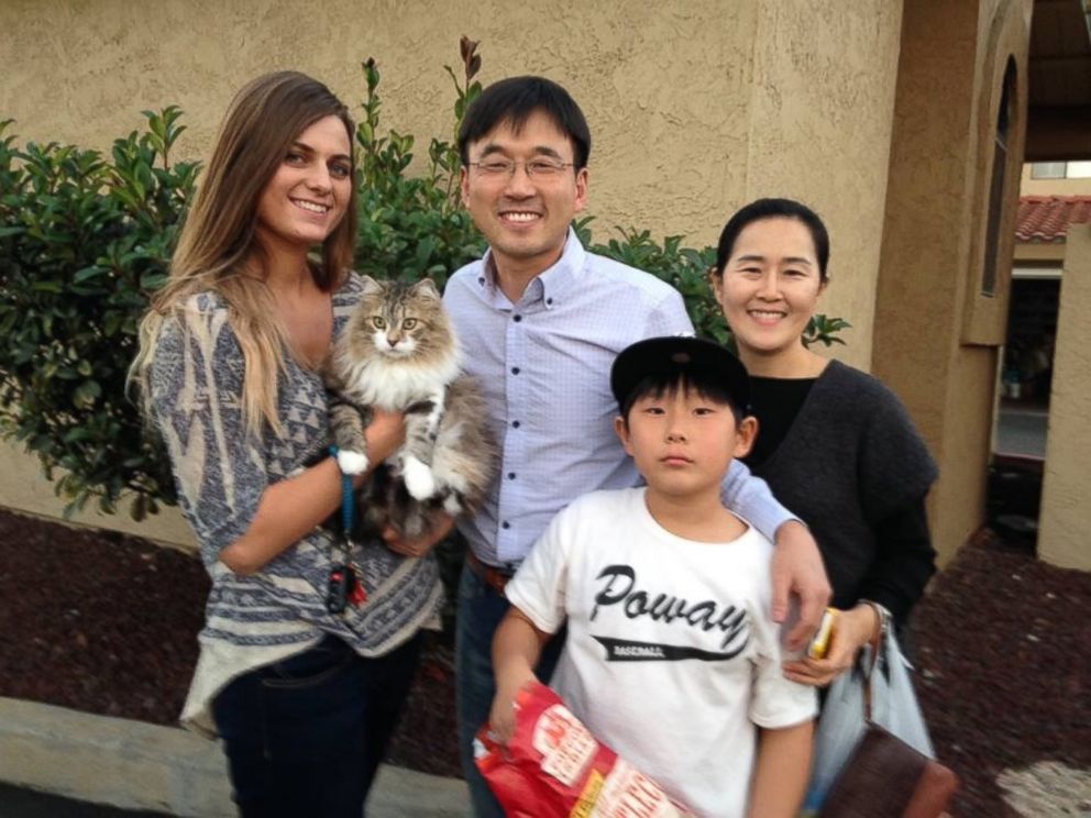 PHOTO: Lulu is pictured with her owner and the family whose car she was under.