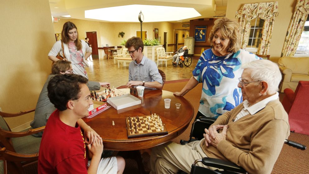 PHOTO: Trish Gaylord visits with her father, Bill Nangle, 89, as he plays a game of chess with Ryan Howard, May 11, 2016, at Creasy Springs Health Campus, in Lafayette, Ind.
